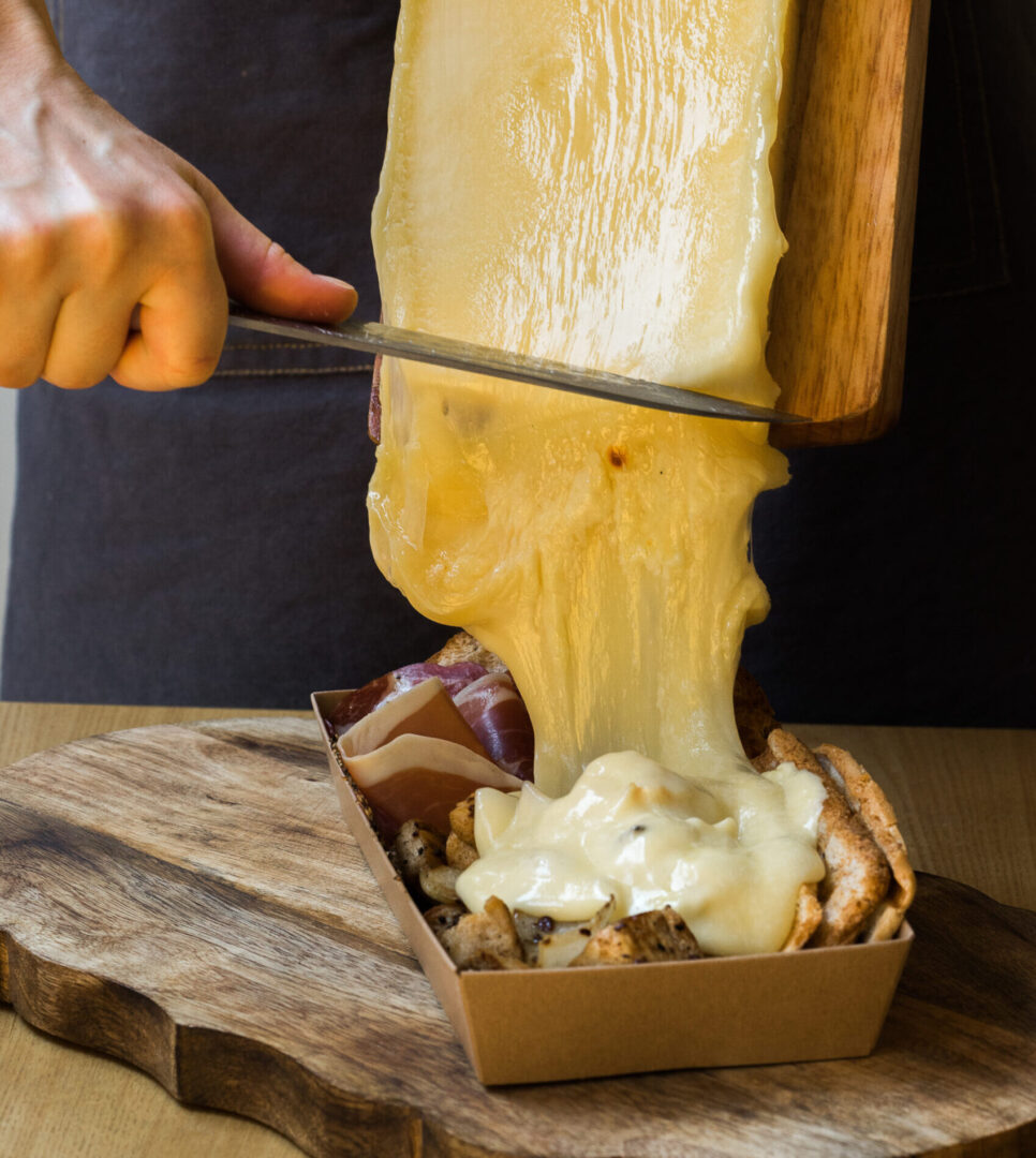 man pouring raclette cheese