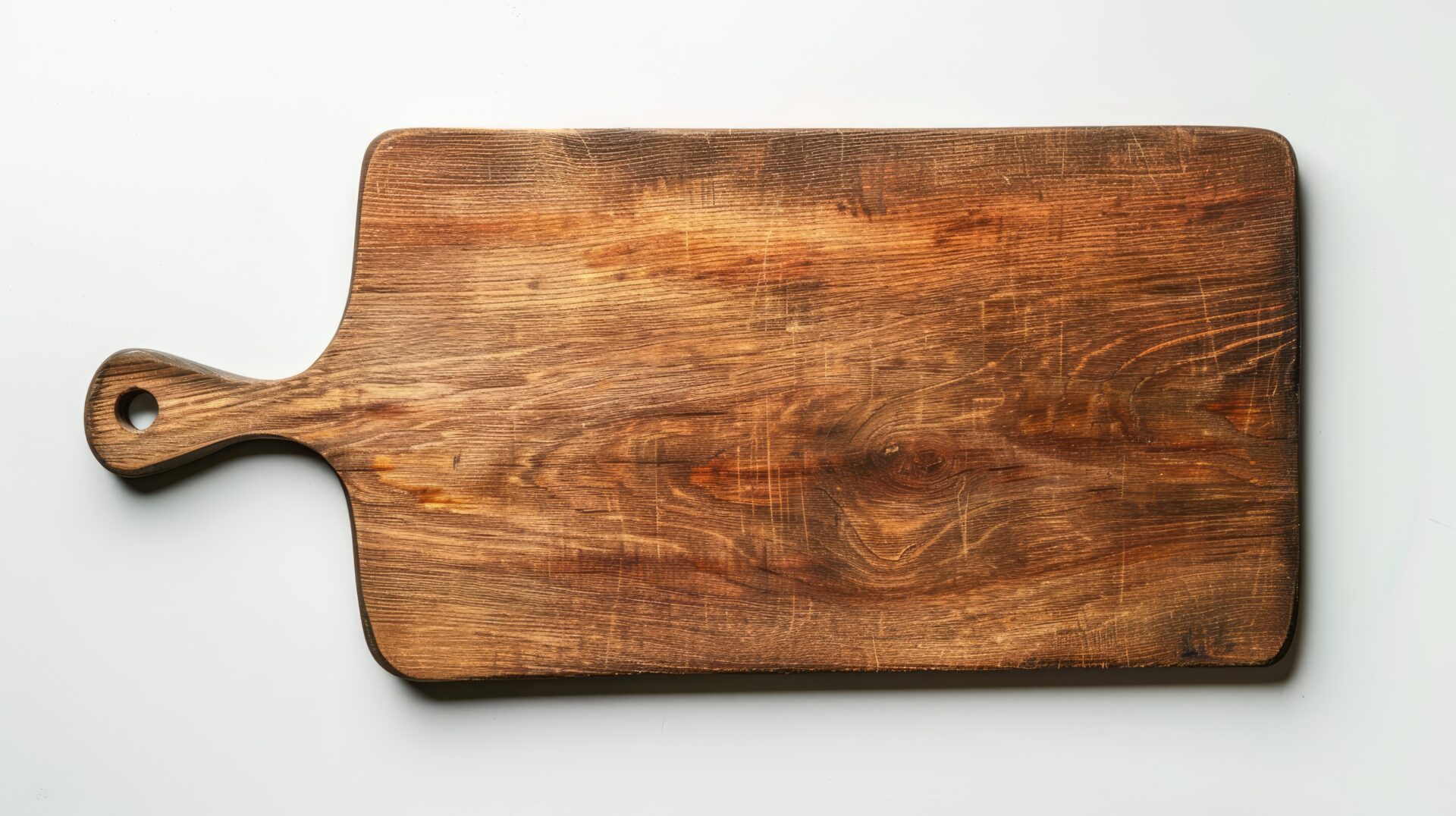 Top view of a single wooden cutting board on a white surface