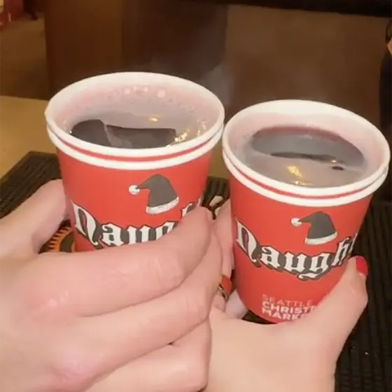 Hands holding cups of warm wine.